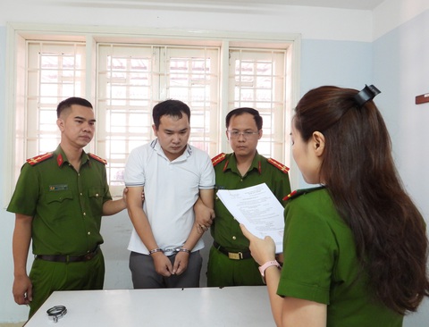 Giám đốc nhận cọc hàng chục tỉ mua đất nhưng mang đầu tư chứng khoán, tiền ảo thua sạch - Ảnh 1. Cơ quan cảnh sát điều tra tống đạt các quyết định đối với bị can - Ảnh: H.B.