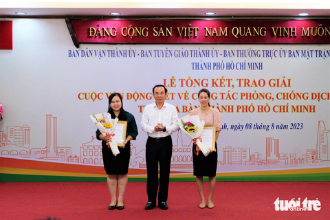 Hơn 2.200 bài thi về COVID-19: "Không viết bằng chữ mà viết bằng con tim" - Ảnh 2. Bí thư Thành ủy TP.HCM Nguyễn Văn Nên trao giải cho 2 cá nhân đoạt giải nhất - Ảnh: PHƯƠNG NHI