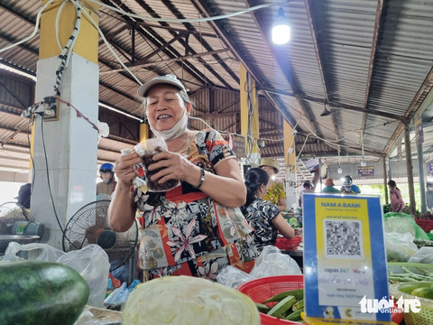 Mua mớ rau ở chợ quê Đà Nẵng cũng quét mã QR, thanh toán 'ting ting' - Ảnh 1. Tiểu thương bán rau ở chợ quê Đà Nẵng đều có mã QR để bà nội trợ thanh toán online - Ảnh: TRƯỜNG TRUNG