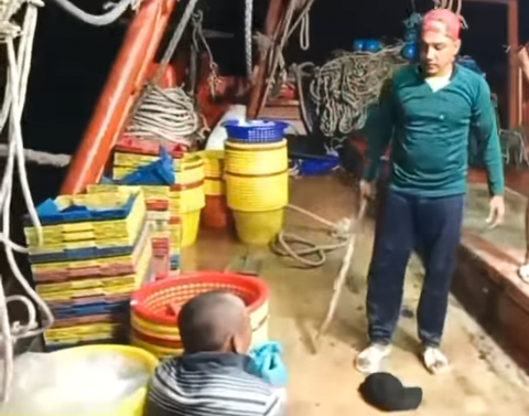 Kiên Giang: Giải cứu 3 ngư dân bị đánh trên tàu cá gây xôn xao cộng đồng mạng - Ảnh 1. Nam thanh niên mặc áo xanh cầm cây dài đánh ngư dân đi chung trên tàu cá khiến cộng đồng mạng bức xúc những ngày qua - Ảnh cắt từ Facebook