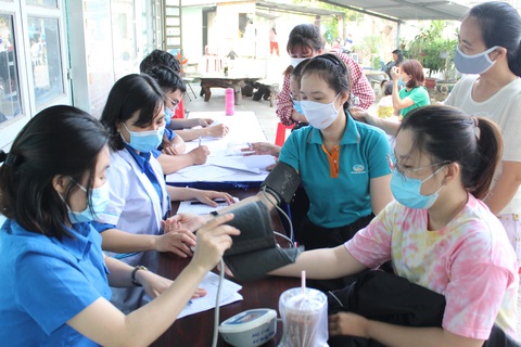 Có nên tăng lương tối thiểu vùng giữa thời điểm khó? - Ảnh 2. Hỗ trợ thăm khám, tư vấn sức khỏe cho công nhân làm việc tại các khu chế xuất - khu công nghiệp ở TP.HCM - Ảnh: Q.L.