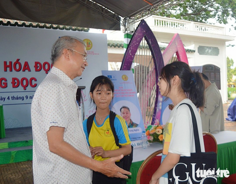 ChatGPT có thể thay thế sách và tự đọc sách không? - Ảnh 2. Nhà báo, tác giả Dương Thành Truyền trò chuyện thêm với học sinh sau buổi giao lưu - Ảnh: ĐẶNG TUYẾT