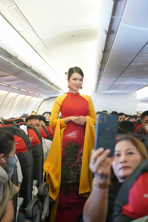 Kỷ niệm Quốc Khánh trên độ cao 10.000 mét - Ảnh 7. Tà áo dài được trình diễn ở độ cao 10.000m. Ảnh: VIETJET