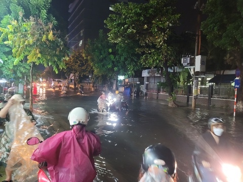 Mưa kéo dài 1 tiếng, điểm nóng ngập lụt Đà Nẵng đã lênh láng nước - Ảnh 3. Người dân đi lại trên vỉa hè khi qua đường Quang Trung để tránh nước ngập - Ảnh: TR.TRUNG