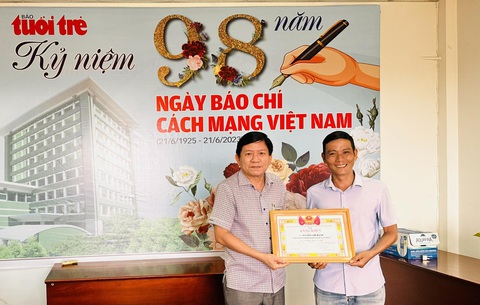 Trao giấy khen cho phóng viên Tuổi trẻ có hành động dũng cảm cứu người - Ảnh 1. Nhà báo Hoàng Trí Dũng trao giấy khen cho phóng viên Chí Hạnh (bên phải) vì hành động dũng cảm cứu người - Ảnh: LAN NGỌC