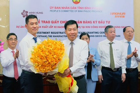 Công ty lốp xe top 10 Trung Quốc đầu tư dự án 500 triệu đô ở Bình Phước - Ảnh 2. Bí thư Tỉnh ủy Bình Phước Nguyễn Mạnh Cường (phải) tặng hoa chúc mừng cho đại diện nhà đầu tư - Ảnh: AN BÌNH