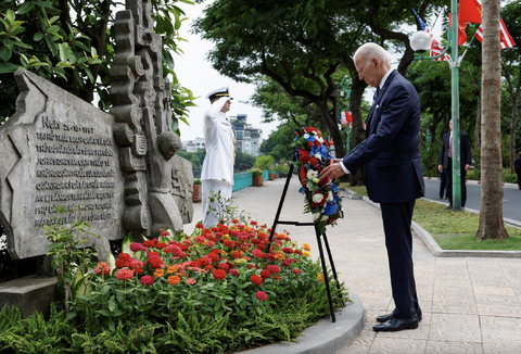 Chuyến thăm Việt Nam của Tổng thống Joe Biden qua ảnh - Ảnh 15. Tổng thống Mỹ Joe Biden đặt hoa tại phù điêu cố thượng nghị sĩ Mỹ John McCain ở Hà Nội chiều 11-9 - Ảnh: REUTERS