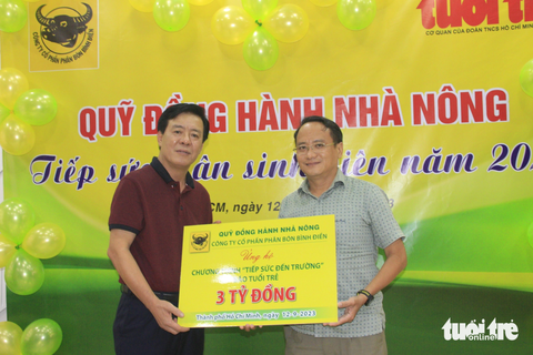 Nghị lực của tân sinh viên nghèo là bài học để chúng tôi nỗ lực làm việc - Ảnh 1. Ông Ngô Văn Đông (bên trái) trao số tiền 3 tỉ đồng cho Phó tổng biên tập báo Tuổi Trẻ Nguyễn Hoàng Nguyên - Ảnh: CÔNG TRIỆU