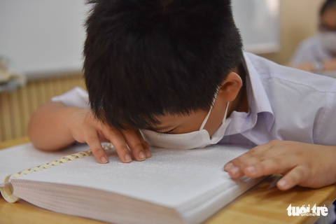 Em học sinh Nguyễn Huỳnh Vũ Duy dò đọc sách chữ nổi ở trường Trường Phổ thông đặc biệt Nguyễn Đình Chiểu (quận 10, TP.HCM) - Ảnh: NGỌC PHƯỢNG Học sinh Nguyễn Huỳnh Vũ Duy dò đọc sách chữ nổi ở Trường phổ thông đặc biệt Nguyễn Đình Chiểu (quận 10, TP.HCM) - Ảnh: NGỌC PHƯỢNG