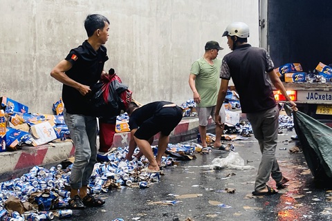 Hàng trăm thùng bia đổ xuống đường, hầm chui ngã tư Vũng Tàu ùn tắc - Ảnh 1. Người dân hỗ trợ tài xế thu gom bia rơi vãi ra đường sau sự cố - Ảnh: AN BÌNH
