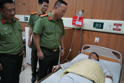 Đại úy công an bị đâm trọng thương khi ngăn cản một vụ đánh ghen - Ảnh 1. Đại tá Phạm Thanh Hùng thăm hỏi tình hình sức khỏe đại úy Hà Việt Anh - Ảnh: Công an cung cấp