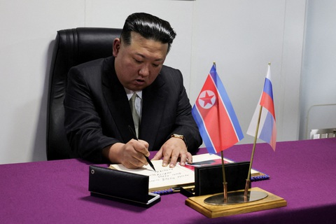 Ông Kim Jong Un mục sở thị tiêm kích MiG-31I trang bị tên lửa siêu vượt âm Kinzhal ở Nga - Ảnh 6. Sau khi xem hệ thống tên lửa và hệ thống pháo binh của tàu khu trục Marshal Shaposhnikov, ông Kim Jong Un viết lưu niệm trong cuốn sổ của các du khách danh dự - Ảnh: REUTERS