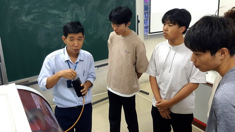 Sinh viên Nhật sang Việt Nam học nghề - Ảnh 1. ThS Nguyễn Văn Thông hướng dẫn cho các sinh viên Nhật trong giờ học về máy phay, tiện CNC - Ảnh: TRỌNG NHÂN