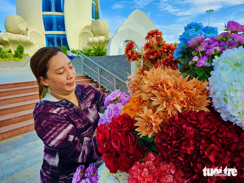 Xe hoa Nha Trang góp bữa sáng 0 đồng cho người nghèo - Ảnh 3. Chị Thảo xếp lại những nhánh hoa đủ màu lên xe - Ảnh: MINH CHIẾN