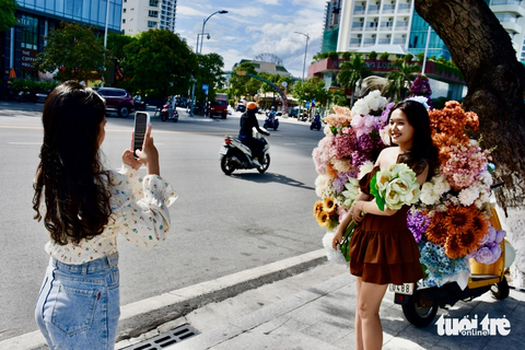 Xe hoa Nha Trang góp bữa sáng 0 đồng cho người nghèo - Ảnh 4. Các bạn trẻ thích thú chụp ảnh với xe hoa - Ảnh: MINH CHIẾN