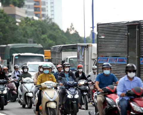 vào những khung giờ cao điểm lượng xe máy xe ô tô lưu thông đang xen nhau Người đi xe máy ở khung giờ cao điểm tại nút giao thông An Phú, TP.HCM