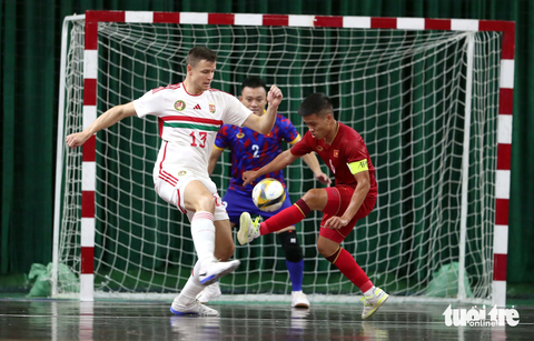 Tuyển futsal Việt Nam thua Hungary 1-4 - Ảnh 1. Đội trưởng Phạm Đức Hòa (phải) bất lực trước hàng thủ futsal Hungary - Ảnh: N.K