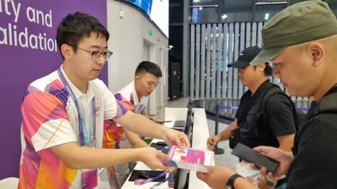 Phóng viên Tuổi Trẻ có mặt tại Asiad Hàng Châu - Ảnh 2. Tình nguyện viên hỗ trợ phóng viên kích hoạt thẻ tác nghiệp - Ảnh: H.Đ.