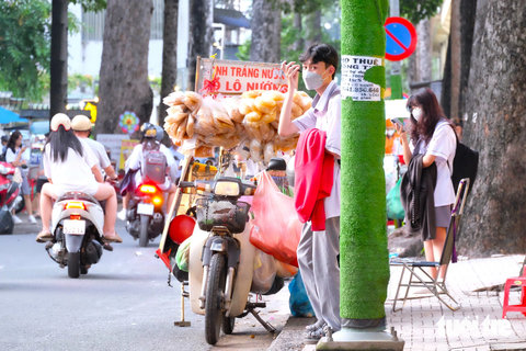 Quấn 'cỏ' quanh cột đèn vẫn bó tay với nạn dán quảng cáo, rao vặt - Ảnh 2. Tại một số cột đèn, cột điện trên đường Nguyễn Kim (quận 5), các tờ quảng cáo, rao vặt được cố định bằng băng keo trong bên trên thảm cỏ nhân tạo
