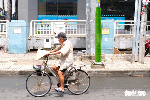 Quấn 'cỏ' quanh cột đèn vẫn bó tay với nạn dán quảng cáo, rao vặt - Ảnh 4. Mỗi thảm cỏ nhân tạo quấn quanh các cột đèn, cột điện dài khoảng 2,5 mét