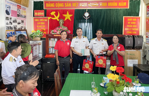 Đoàn công tác TP.HCM thăm nhà giàn DK1 - ngôi nhà chung của ngư dân vùng biển Tây Nam - Ảnh 2. Bà Trần Kim Yến - chủ tịch Ủy ban MTTQ Việt Nam TP.HCM (bìa phải) - trao quà cho các chiến sĩ tại nhà giàn DK1 - Ảnh: CHÂU TUẤN