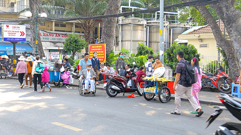 Thu phí lòng đường, vỉa hè tại TP.HCM: Mong làm sớm - Ảnh 1. Vỉa hè đường Dương Quang Trung (đoạn trước Viện Tim, quận 10, TP.HCM) bị lấn chiếm bán hàng ăn uống gây khó khăn cho người đi bộ - Ảnh: PHƯƠNG QUYÊN