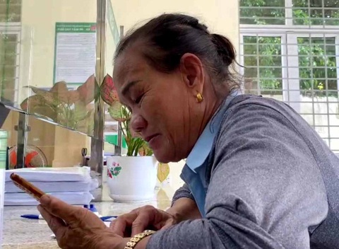 “Giải cứu” người phụ nữ suýt bị lừa đảo gần 50 triệu đồng - Ảnh 1. Bà Hạnh nghe cuộc gọi của nhóm lừa đảo - Ảnh: N.V