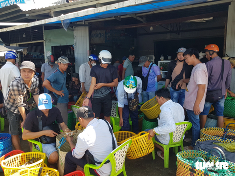 Độc đáo mô hình 'chợ trời đấu giá cua' biển ở Vĩnh Thuận - Ảnh 1. Toàn cảnh "chợ trời đấu giá cua" tại dốc cầu Vĩnh Thuận đang thu hút sự quan tâm của các thương lái thu mua cua - Ảnh: BỬU ĐẤU