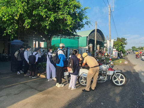 36 em học sinh trước trường THPT huyện đi xe máy sai luật, phụ huynh cũng bị phạt - Ảnh 1. Hàng loạt học sinh đi xe máy sai luật bị xử phạt - Ảnh: AN LONG