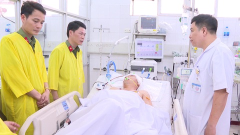 Can ngăn nhóm thanh niên “hỗn chiến”, trung úy công an bị trúng đạn phải cấp cứu - Ảnh 1. Đại tá Nguyễn Hữu Mạnh (thứ hai từ trái qua) - phó giám đốc Công an tỉnh Thanh Hóa - thăm hỏi sức khỏe trung úy Phan Tiến Dũng đang điều trị tại Bệnh viện Hữu nghị Việt Đức - Ảnh: Công an tỉnh Thanh Hóa cung cấp