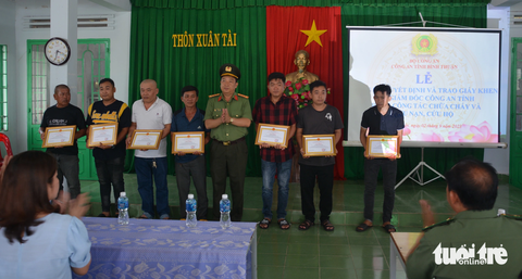 Chủ tịch tỉnh tặng bằng khen người bị điện giật trong vụ cháy ở Phan Thiết - Ảnh 2. Đại tá Trần Văn Mười - phó giám đốc Công an tỉnh Bình Thuận - trao tặng giấy khen của giám đốc công an tỉnh đến những người dân cùng tham gia hỗ trợ trong vụ cháy - Ảnh: ĐỨC TRONG