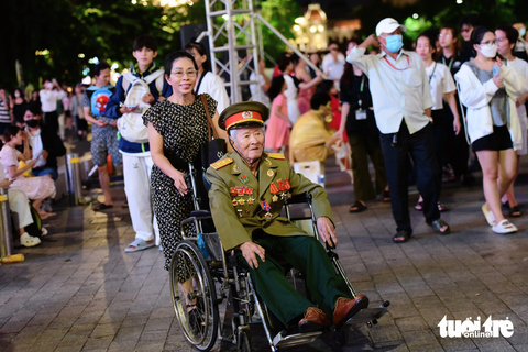 Người dân đổ về trung tâm TP.HCM ngắm pháo hoa - Ảnh 4. Cụ ông Nguyễn Văn Thành (95 tuổi) được con gái đưa đi ngắm nhìn thành phố dịp lễ - Ảnh: DUYÊN PHAN
