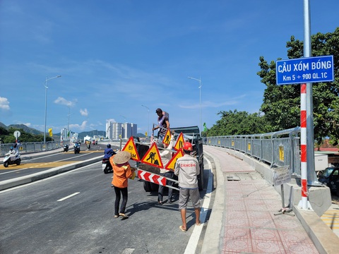Đưa vào khai thác cầu Xóm Bóng, giảm kẹt xe trên cầu Trần Phú ở Nha Trang - Ảnh 3. Đơn vị thi công thu dọn rào chắn trên cầu Xóm Bóng mới khi cây cầu chính thức vận hành lúc 14h ngày 20-9 - Ảnh: TRẦN HƯỚNG