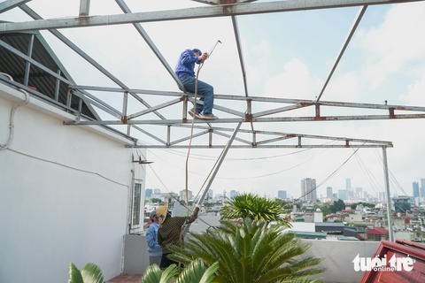 Tháo dỡ 'chuồng cọp', mở lối thoát hiểm tại chung cư mini sai phép của ông Nghiêm Quang Minh - Ảnh 2. Các khung sắt trên tầng thượng được tháo dỡ - Ảnh: PHẠM TUẤN