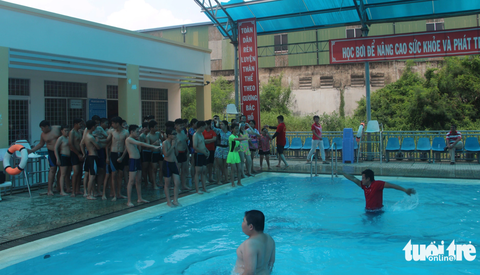 Gần 150 học sinh khuyết tật được dạy bơi phòng, chống tai nạn đuối nước - Ảnh 2. Các huấn luyện viên hướng dẫn kỹ năng bơi cho các em học - Ảnh: HOÀI THƯƠNG