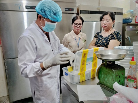 Bánh mì Phượng xin lỗi khách, nói là sơ sót trong quy trình kiểm soát nhập nguyên liệu đầu vào - Ảnh 1. Bà Trương Thị Phượng (bìa phải), chủ cơ sở bánh mì Phượng, lúc cơ quan chức năng lấy mẫu thực phẩm xét nghiệm - Ảnh: Sở Y tế Quảng Nam
