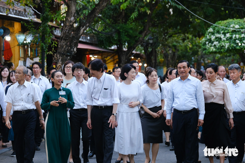Hoàng thái tử Akishino và Công nương Kiko dạo phố cổ Hội An, vẫy tay chào người dân - Ảnh 1. Hoàng thái tử và Công nương (giữa) nghe thuyết minh về phố cổ Hội An khi đi tham quan đường Nguyễn Thị Minh Khai - Ảnh: TẤN LỰC