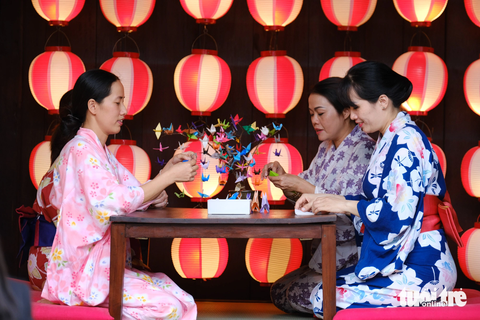 Hoàng thái tử Akishino và Công nương Kiko dạo phố cổ Hội An, vẫy tay chào người dân - Ảnh 6. Các nghệ nhân Trung tâm văn hóa Hội An trong trang phục kimono trình diễn nghệ thuật gấp giấy Origami - Ảnh: TẤN LỰC