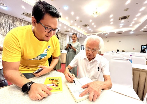 Cha đẻ câu "mỗi ngày đến trường là một ngày vui" chỉ cách "dụ" học sinh thích đến trường - Ảnh 2. Giáo sư Hồ Ngọc Đại ký tặng sách cho người hâm mộ tại lễ ra mắt sách - Ảnh: MỸ DUNG