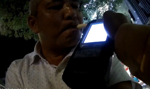 Tài xế xe biển xanh có nồng độ cồn thừa nhận có uống bia chứ không phải uống nước trái cây - Ảnh 1. Tài xế H. thời điểm bị yêu cầu đo nồng độ cồn - Ảnh cắt từ clip của Cục CSGT