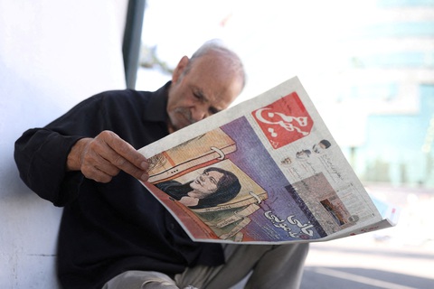 Một người đàn ông xem tờ báo có ảnh bìa là hình Mahsa Amini ở Tehran, Iran, ngày 18-9-2022. Một người đàn ông xem tờ báo có ảnh bìa là hình Mahsa Amini ở Tehran, Iran, ngày 18-9-2022 - Ảnh: REUTERS