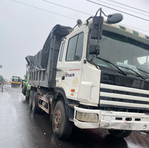 Phương tiện thi công của Công ty CP Quản lý và xây dựng đường bộ Bình Định - Ảnh: DUY MẠNH Công ty cổ phần Quản lý và Xây dựng đường bộ Bình Định thảm nhựa đường lúc trời đang mưa - Ảnh: DUY MẠNH