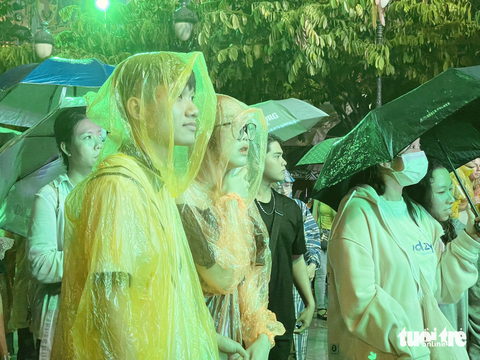 Quán quân Sing my song Cao Bá Hưng thi 'Cảm hứng Hò Dô' - Ảnh 4. Nhiều bạn trẻ mặc áo mưa, che ô để thưởng thức những phần trình diễn của các thí sinh - Ảnh: THÁI THÁI