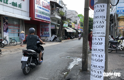 Rao vặt, vẽ bậy: Chẳng lẽ bó tay mãi sao? - Ảnh 3. Quảng cáo cho vay dán đầy cột điện - Ảnh: KHOA NAM