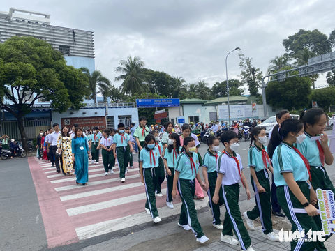 TP.HCM: Chú ý nhường đường cho học sinh đi bộ an toàn - Ảnh 3. Thầy, cô giáo dẫn các em học sinh Trường THCS Hà Huy Tập sang đường đúng cách, an toàn - Ảnh: THU DUNG