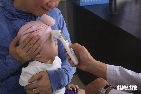 Bác sĩ về hưu tại trạm y tế: Cống hiến hết mình vì người bệnh - Ảnh 4. Đến khoảng 8h, người dân đến trạm y tế bắt đầu đông hơn, bác sĩ Khang nhanh chóng hỗ trợ các bác sĩ tại trạm thăm khám, hỗ trợ cho từng bà con - Ảnh: THU HIẾN