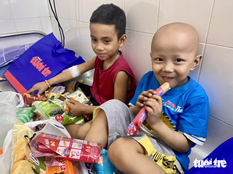 'Ước mơ của Thúy' mang Trung thu đến bệnh nhi Đà Nẵng, Huế - Ảnh 4. Các em mở bánh và xúc xích ăn ngay khi được nhận quà - Ảnh: ĐOÀN NHẠN