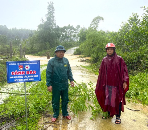 Cầu tràn bị nước nhấn chìm, đường 'độc đạo' vào bản Rào Tre bị chia cắt - Ảnh 1. Lực lượng chức năng cấm biển cảnh báo trên tuyến đường dẫn vào bản Rào Tre - Ảnh: H.A.