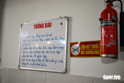 Người Hà Nội lắp đủ loại thang thoát hiểm, có thang dựng đứng, lấn ra cả vỉa hè - Ảnh 5. Những nội quy về phòng cháy chữa cháy cùng việc sử dụng thang thoát hiểm được ghi rõ tại bảng thông báo ở tầng 1 - Ảnh: HỒNG QUANG