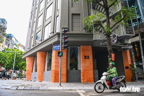 Người Hà Nội lắp đủ loại thang thoát hiểm, có thang dựng đứng, lấn ra cả vỉa hè - Ảnh 9. Một khách sạn trên đường Trần Thái Tông, quận Cầu Giấy, dùng loại thang có thể gấp gọn lên phía trên khi không sử dụng - Ảnh: HỒNG QUANG